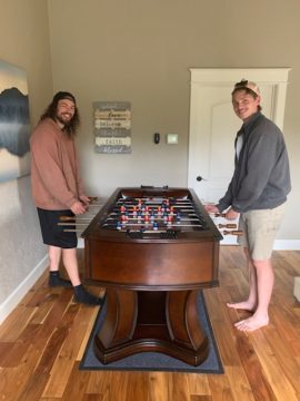 two adult males playing foosball table